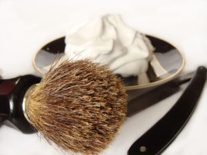 A close up of a shaving brush and razor