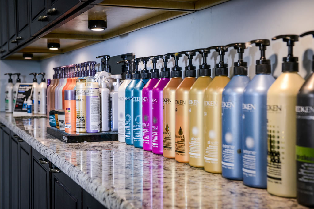 A counter with many bottles of hair products on it.